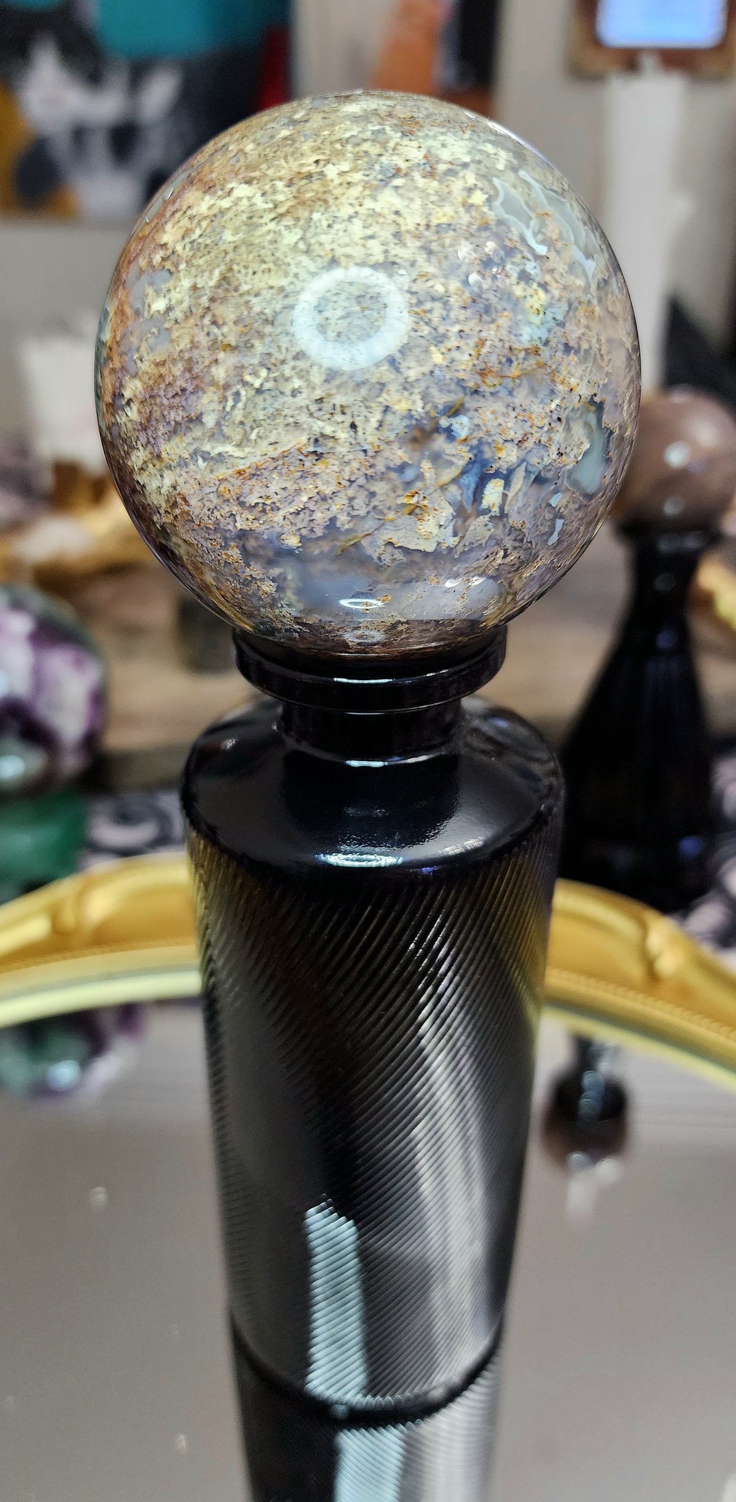 Red Moss Agate Sphere on a Black Vase