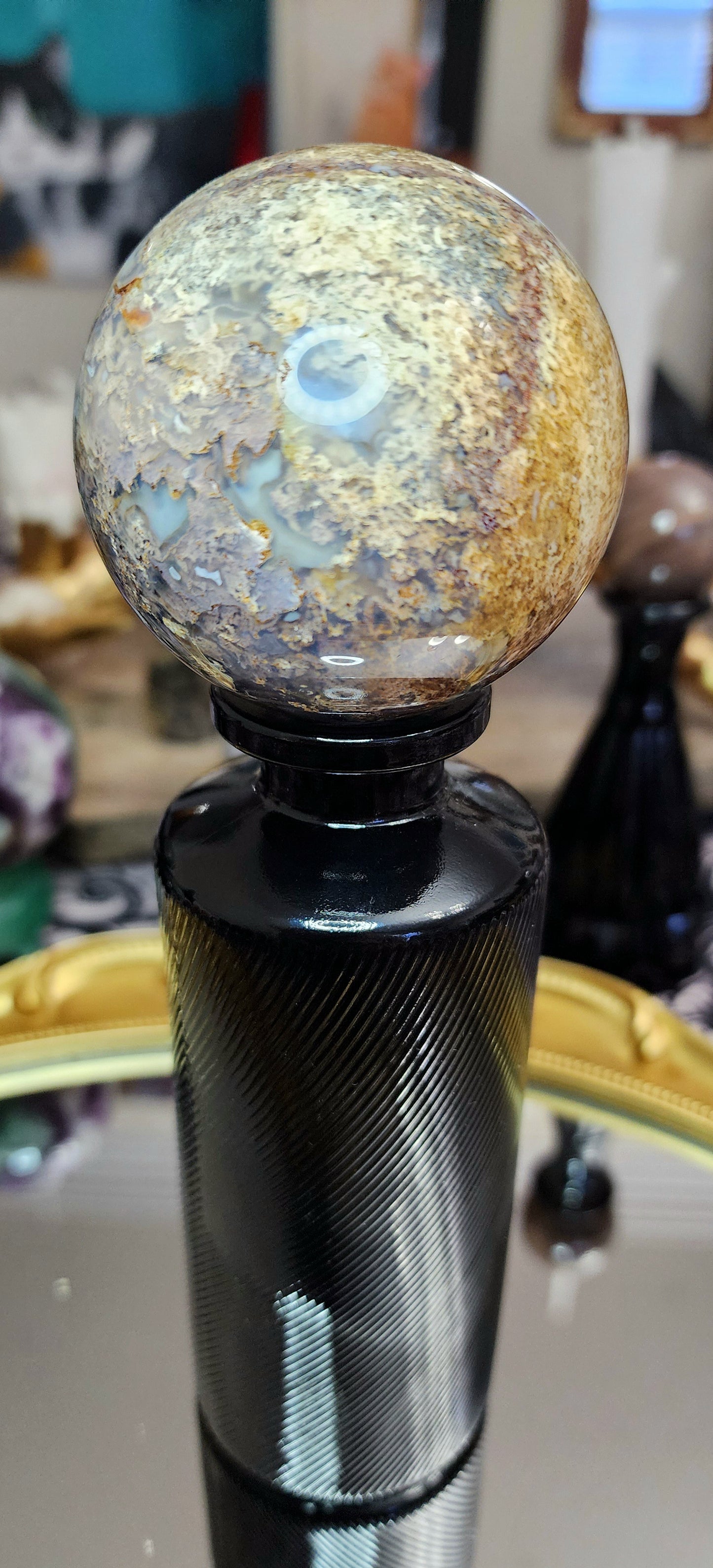 Red Moss Agate Sphere on a Black Vase