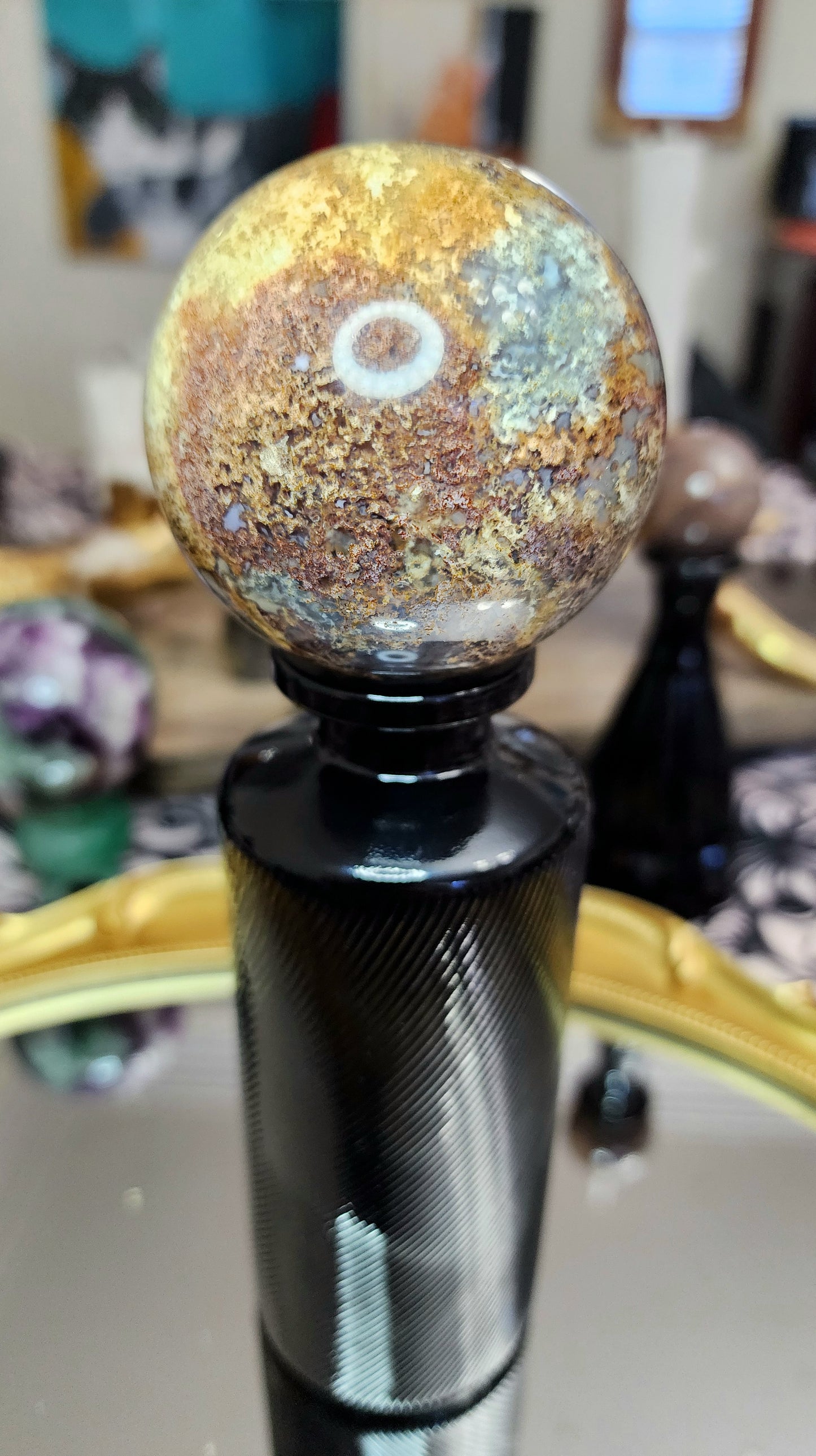 Red Moss Agate Sphere on a Black Vase