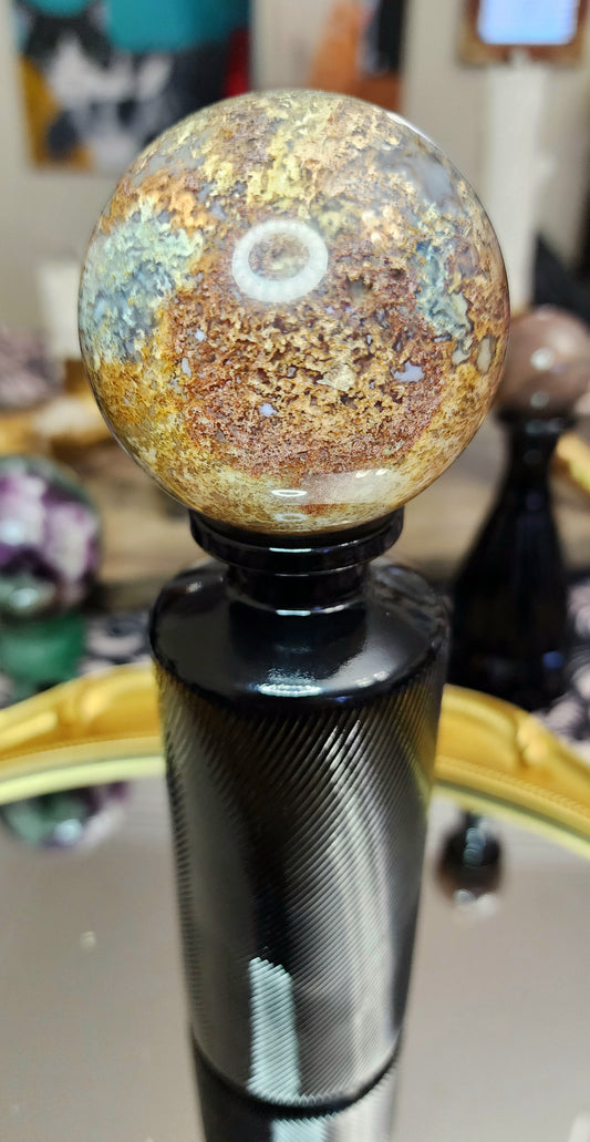 Red Moss Agate Sphere on a Black Vase